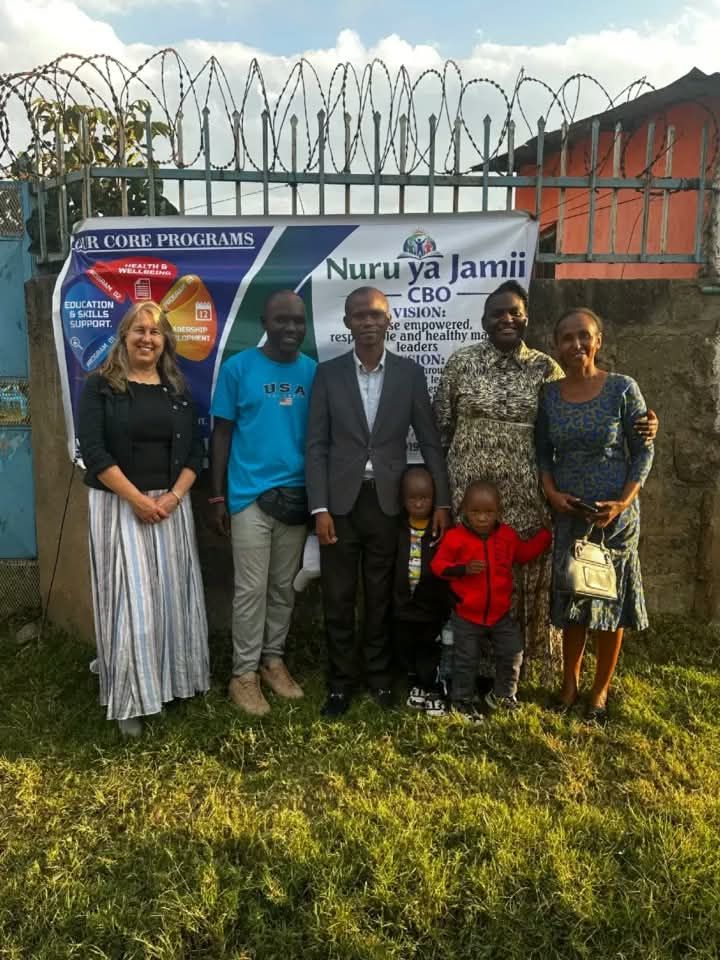 Volunteers and partners with the Nuru ya Jamii banner